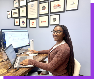 Kaila Anderson, Website SEO and AEO specialist sitting at her desk with two monitors